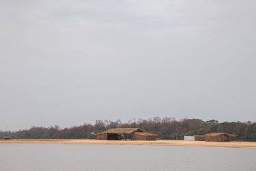 Português: Em Aruanã, durante a vazante do Araguaia, é possível ver algumas casas de palha utilizadas por pescadores, situadas na outra margem do rio.  Aí, no Estado do Mato Grosso, se prolonga o território indígena demarcado como Karajá II. Karajá: Aruanã-ki, bèè rùkỹmyhỹreku iny robilemyhỹre nobò hetoku sohoji sohoji waxidu mahãdu hetoku, knawèbrètxàki riwinymyhỹre. Mato Grosso wèrbiki wahè, tamy iny-su rèhèmnymyhỹ, Área Karajá II rki. 